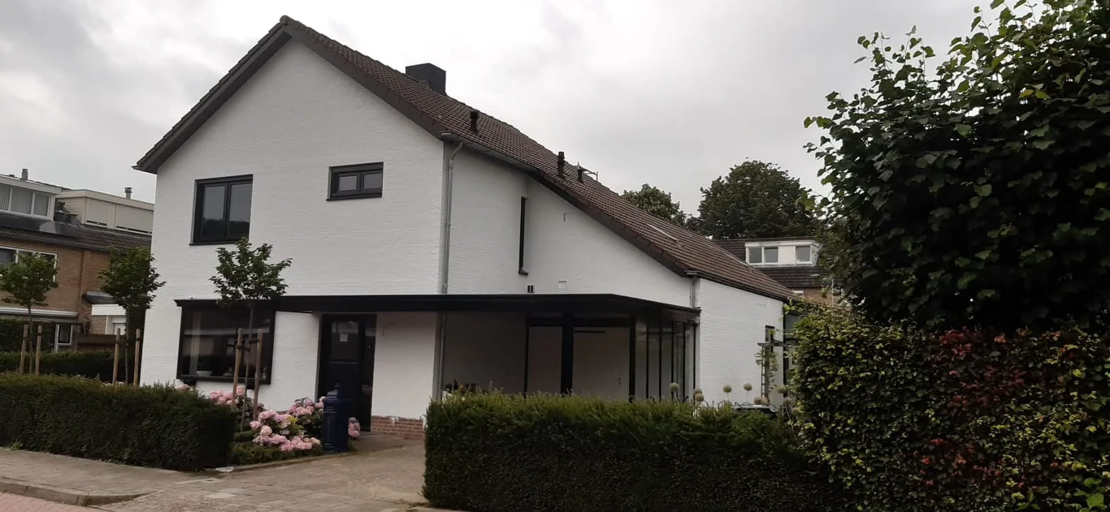 De afgewerkte woning vanaf de zijkant, met de overkapping in antraciet